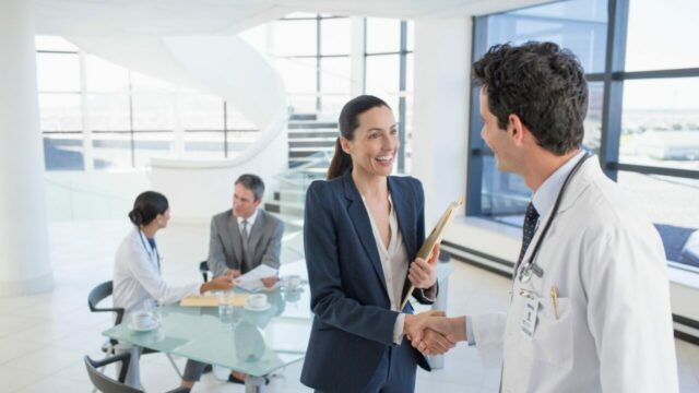 Doctor,And,Businesswoman,Handshaking,In,Meeting Doctor and businesswoman shaking hands